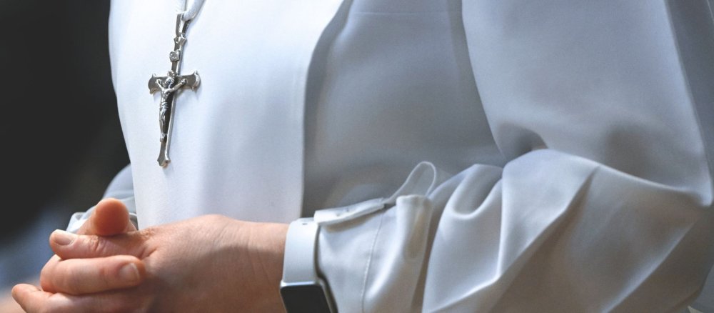 Ordensfrau im weißen Habit mit gefalteten Händen