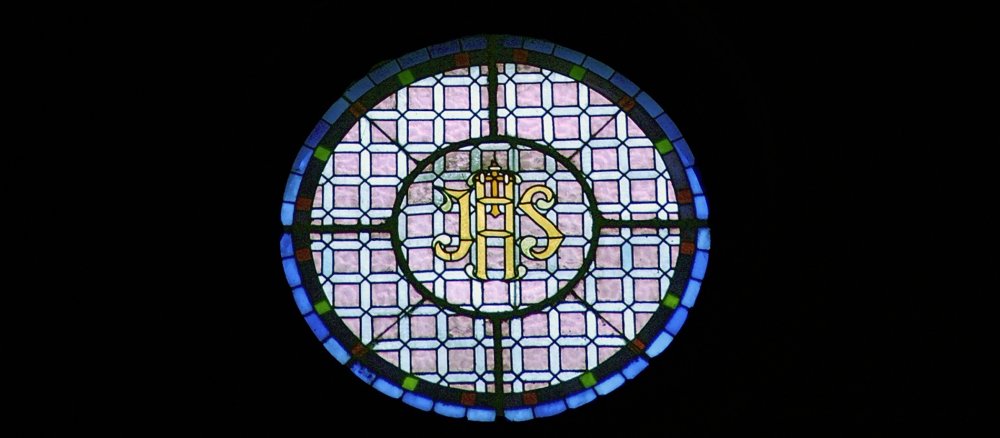 Ein Kirchenfenster in einer Kirche in Sevilla trägt das Christusmonogramm "JHS".