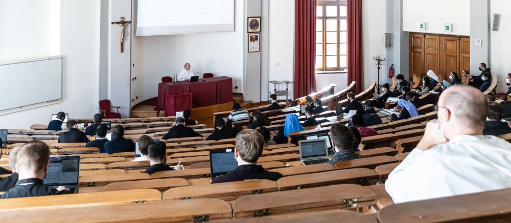 Students, including religious sisters and brothers, during class in a lecture hall at the Pontifical University of Saint Thomas Aquinas on 1 March 2021 in Rome. A crucifix hangs on the wall.