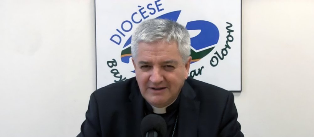 Bishop Marc Aillet at a press conference in front of the logo of the Diocese of Bayonne