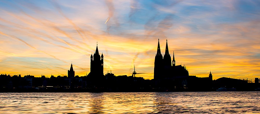Die Silhouette der Kölner Altstadt mit Dom (rechts) und Groß Sankt Martin vom Rhein aus gesehen.
