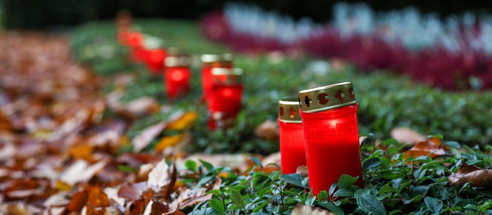 Rote Grablichter stehen im Herbstlaub