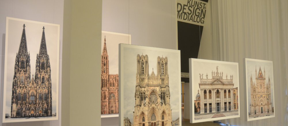 Mehrere Fotografien hängen in einem Ausstellungsraum.