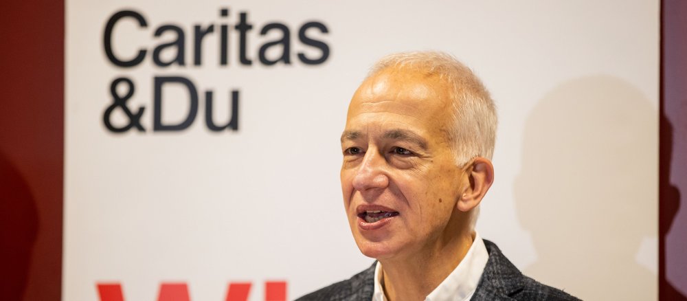 Caritas-Präsident Michael Landau vor einem Banner mit dem Schriftzug "Caritas & Du"