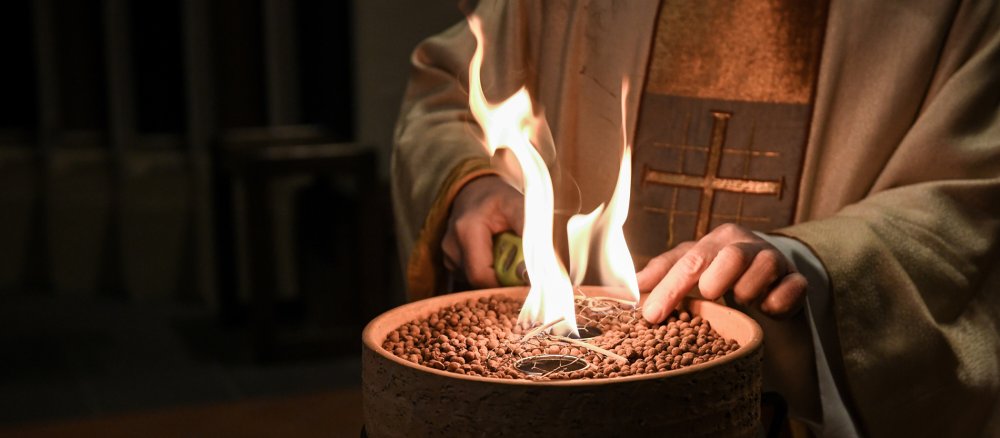 Ein Priester entzündet ein Osterfeuer