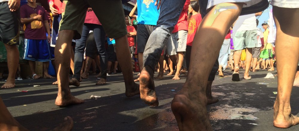 Philippinische Teilnehmer einer Prozession laufen barfuß durch die Straßen