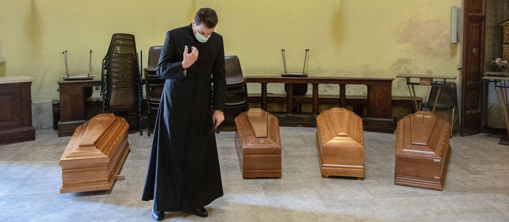 Ein Geistlicher betet am 24. März 2020 bei den Särgen von Opfern des Coronavirus in der Friedhofskapelle in Brescia.