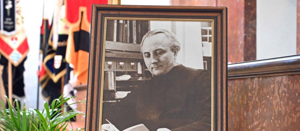 Ein Foto von Max Josef Metzger steht in einer Kirche vor einer Reihe von Bannern