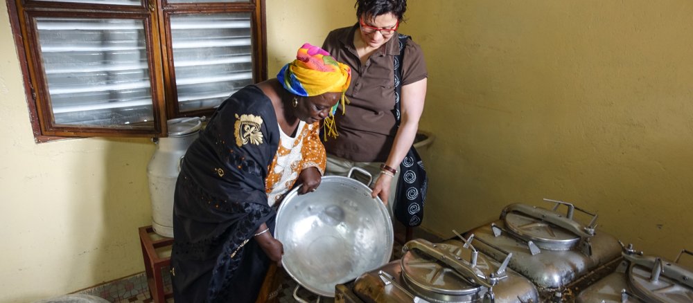 Im Stadtteil Hamdalaye von Ouagadougou zeigt eine Molkerei-Mitarbeiterin einer deutschen Milchviehhalterin am 8. Februar 2017 die lokalen Produktionsbedingungen.