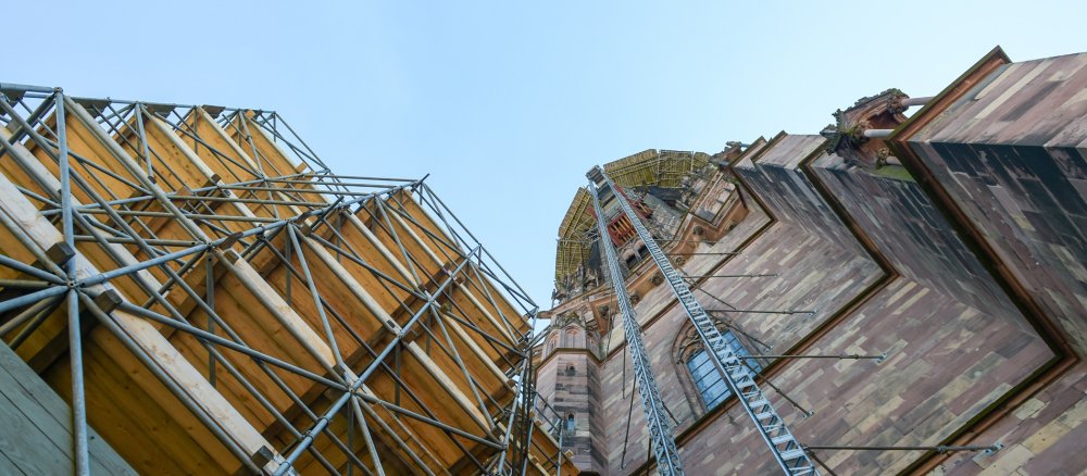 Blick auf Lastenaufzug, Baugerüst und Turmspitze des Freiburger Münsterturms