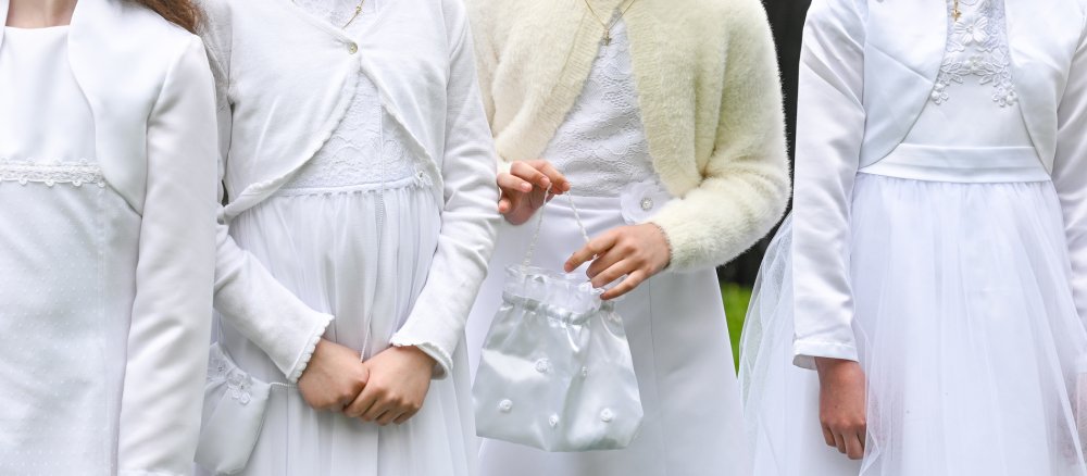 White dresses worn by communion children at a First Communion celebration