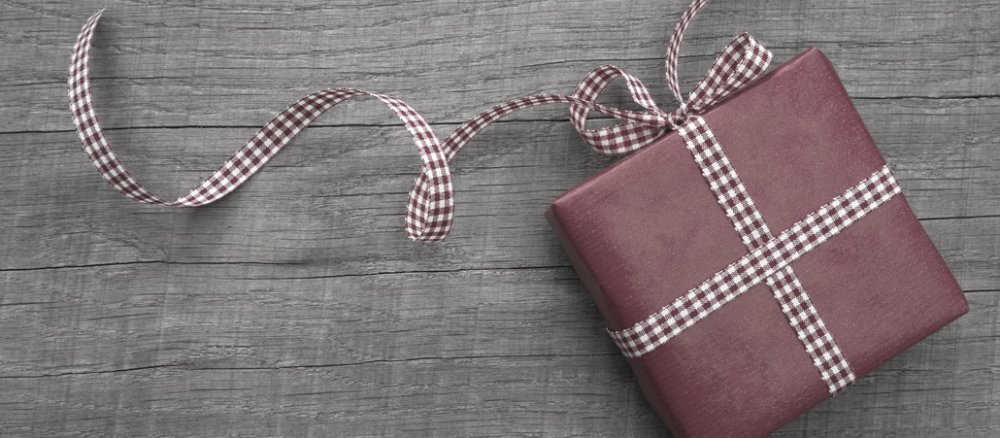 Ein Geschenk auf Holzboden mit reduzierten Farben