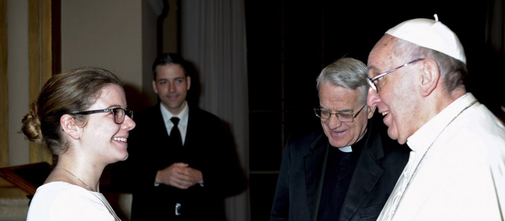 Junge Frau schüttelt Papst Franziskus die Hand.