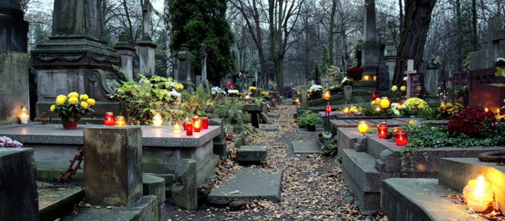 Kerzen brennen auf einem Friedhof.