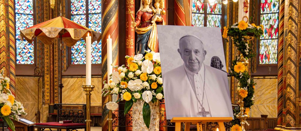 Ein Bild von Papst Franziskus in der Marienbasilika in Kevelaer, im Hintergrund der aufgespannte Basilika-Schirm