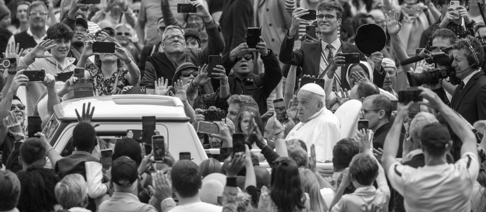 Papst Franziskus im Papamobil umringt von Menschen auf dem Petersplatz