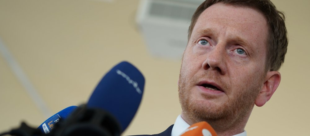 Sachsens Ministerpräsident Michael Kretschmer vor Mikrofonen.