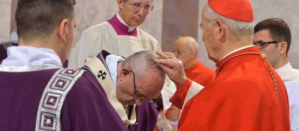 Ein Kardinal zeichnet Franziskus das Aschekreuz auf die Stirn