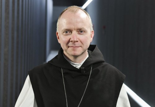 Bischof Erik Varden, Prälat von Trondheim, steht in einem Flur und lächelt in die Kamera