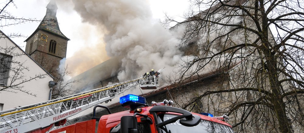Mit einer Drehleiter löscht die Feuerwehr den Brand in der Kirche St. Jodok in Ravensburg