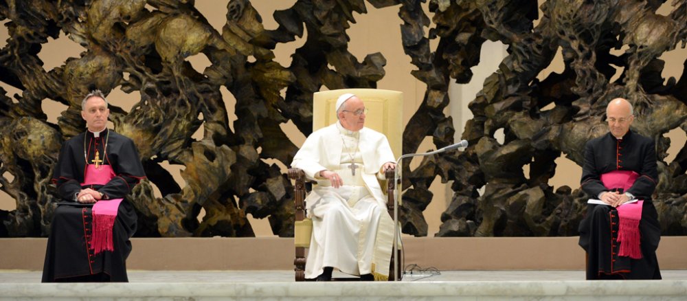 Der Papst sitzt gemeinsaam mit zwei Kardinälen bei einer Audienz.