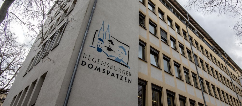 Das Logo der Regensburger Domspatzen vor dem Schulgebäude.