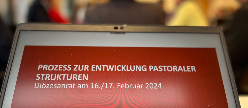 Ein Laptopmonitor zeigt eine Folie mit der Aufschrift "Prozess zur Entwicklung pastoraler Strukturen" für den Diözesanrat am 16. und 17. Februar
