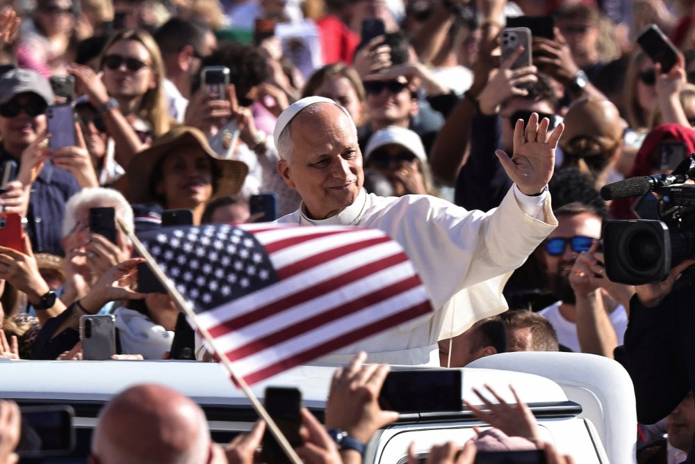 Papst Leo im Papamobil auf dem Petersplatz, vor ihm eine US-Flagge.
