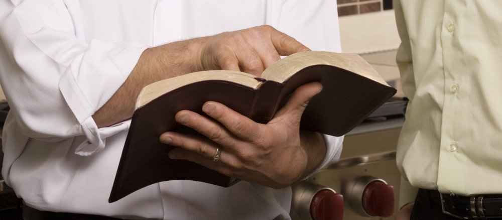 A man shows something in an open book