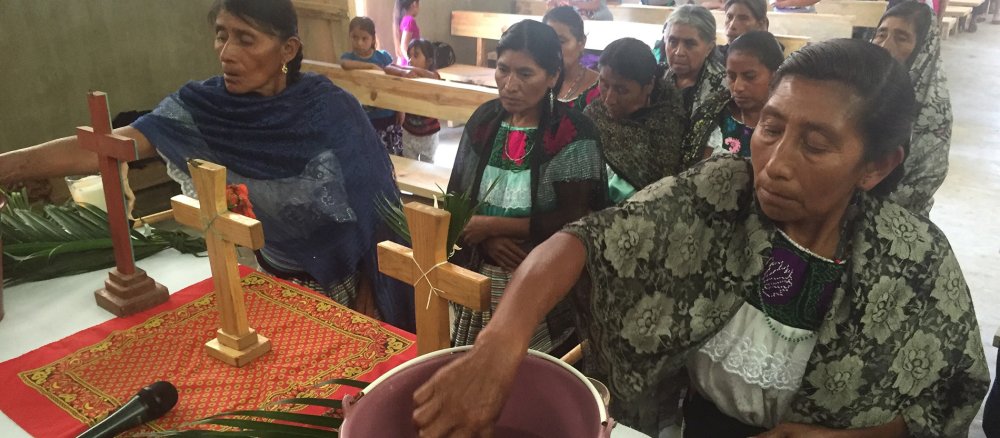 Eine indigene Frau taucht ihre Hand vor einem Gottesdienst am Altar in Weihwasser in Chiapas (Mexiko).
