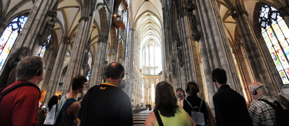 Touristen schauen in Richtung des hohen Deckengewölbes.