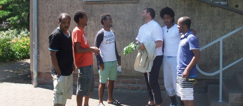 Ein Pfarrer im Gespräch mit Flüchtlingen.