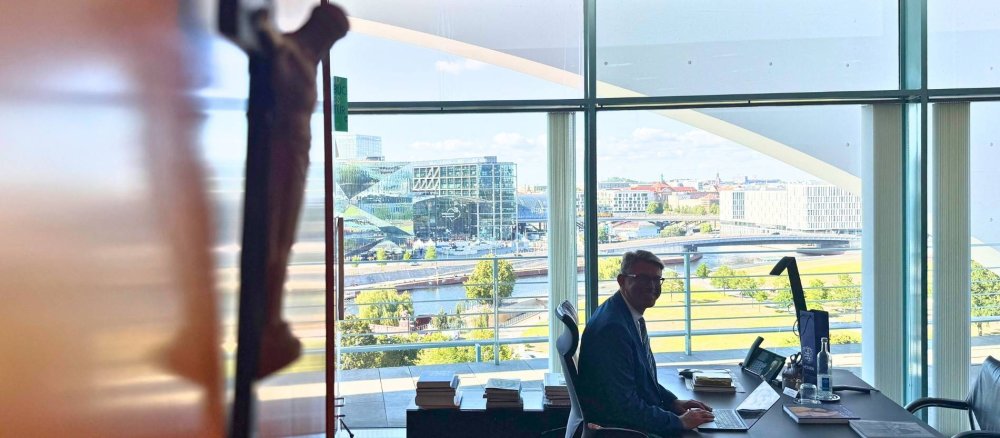 Kulturstaatsminister Wolfram Weimer sitzt in seinem Büro, im Vordergrund ein Kruzifix