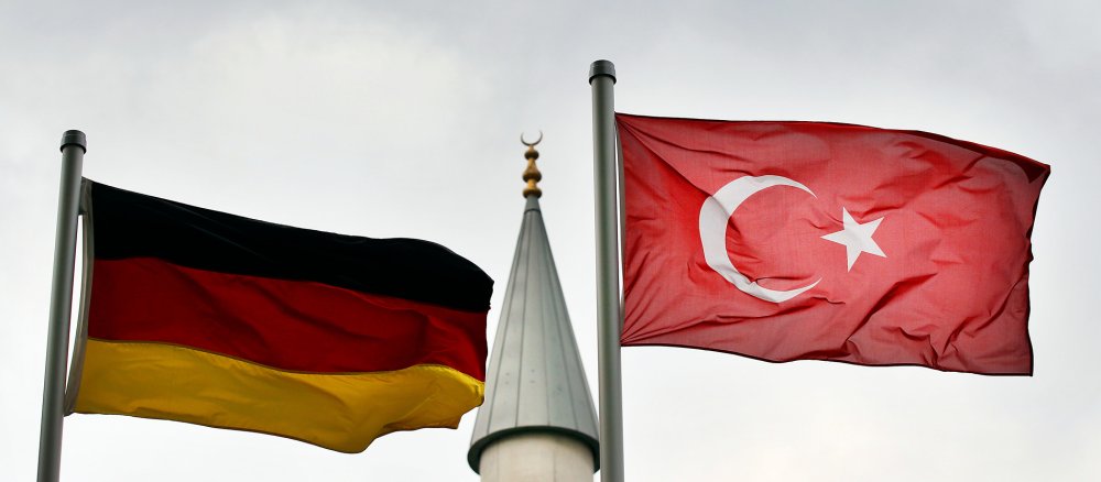 Eine deutsche und eine türkische Fahne wehen am Freitag, 10.09.2010, vor dem Minarett der Merkez-Moschee in Duisburg während des Freitagsgebets.