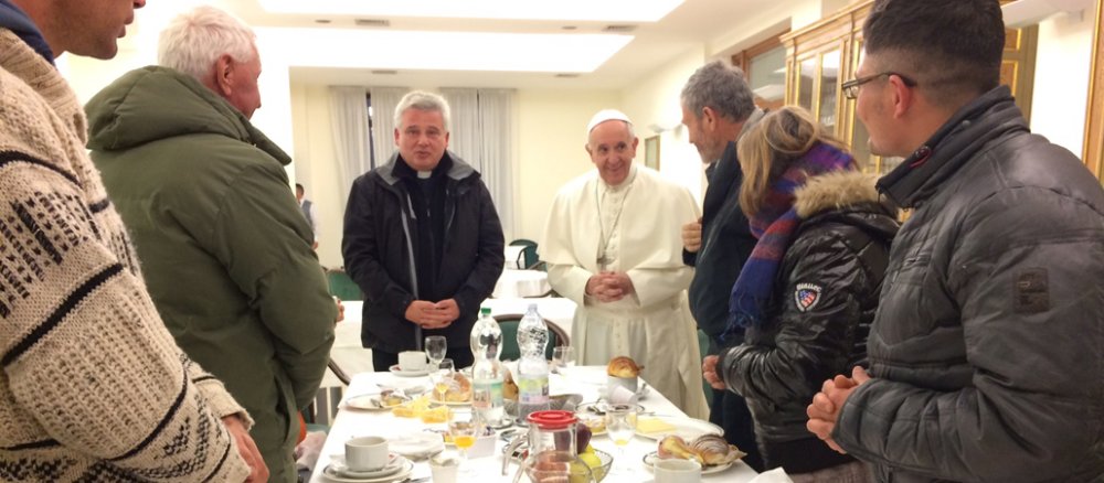 Obdachlose stehen am 17.12.2016 im Vatikan in Rom beim gemeinsamen Frühstück mit Papst Franziskus beim Gebet zusammen.