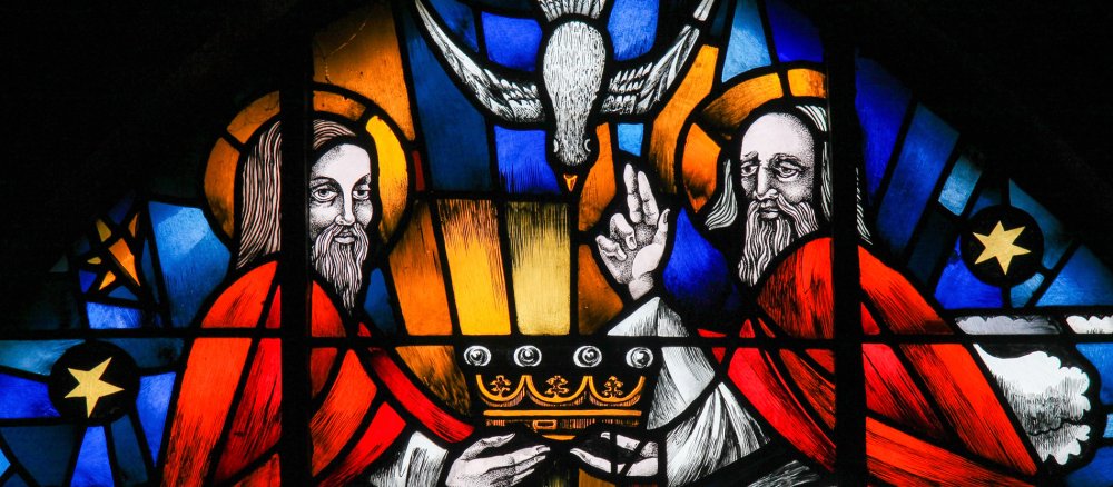 Ein Kirchenfenster zeigt die Dreifaltigkeit Gottes