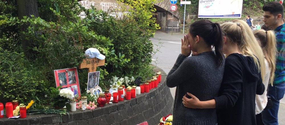 Trauernde legen Blumen und Kerzen am Tatort in Bad Godesberg nieder.