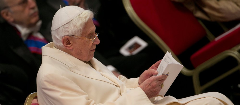 Benedikt XVI. sitzt lesend in einem Stuhl