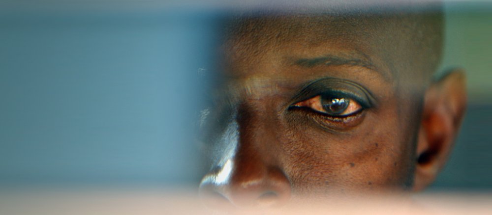 Das Auge eine 49-jährigen Mannes, der am Völkermord beteiligt war, spiegelt sich im Rückspiegel seines Autos.