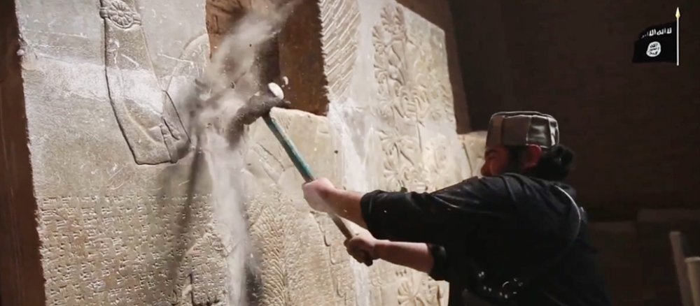 Ein Screenshot aus einem IS-Propaganda-Video soll einen Terroristen zeigen, der im irakischen Nimrud ein antikes Relief zerstört.