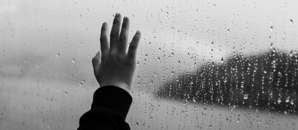 A child's hand on a window pane