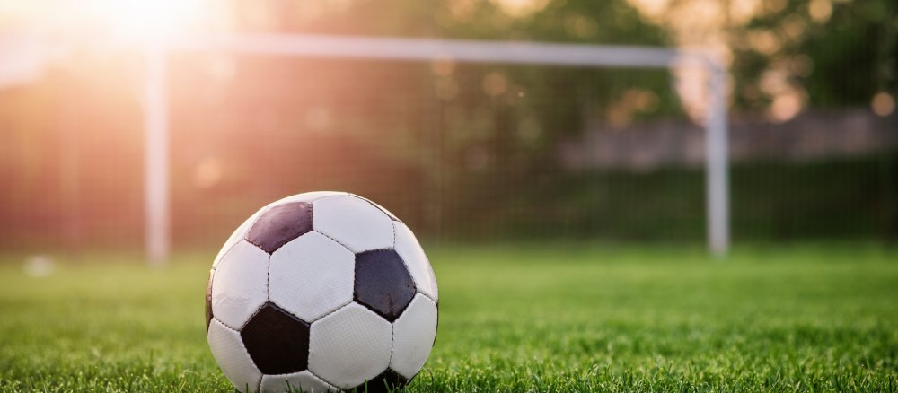 Ein Fußball liegt auf einem Fußballfeld.