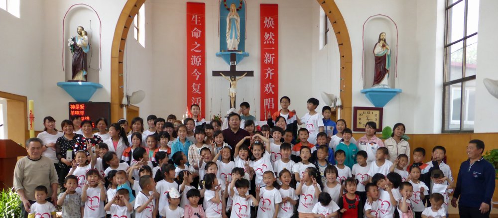 Kinder haben sich vor einem Altar in einer katholischen Kirche in China für ein Gruppenfoto aufgestellt.