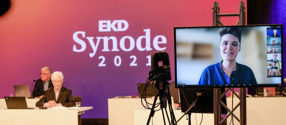 Bei der digitalen Synode der EKD ist Anna-Nicole Heinrich auf einem Bildschirm zugeschaltet.