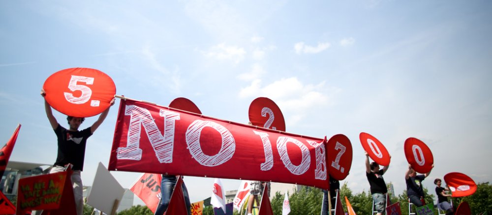 Ein rotes Banner mit der Aufschrift "No Job" vor blauem Himmel.