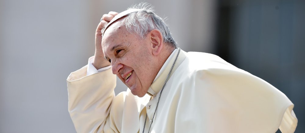 Papst Franziskus greift an das sogenannte Scheitelkäppchen auf seinem Kopf.
