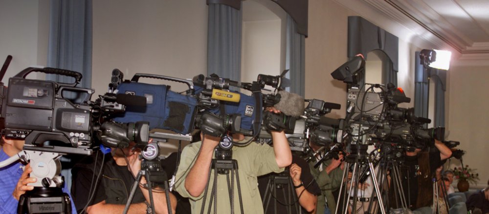 Fernsehkameras bei einer Pressekonferenz.