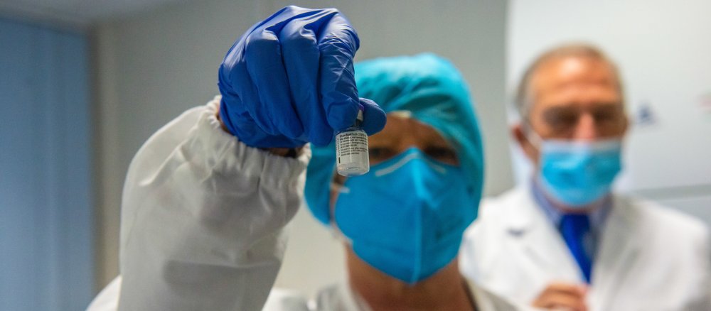 Ein Ärztin hält eine kleine Dosis des Corona-Impfstoffs in der Hand