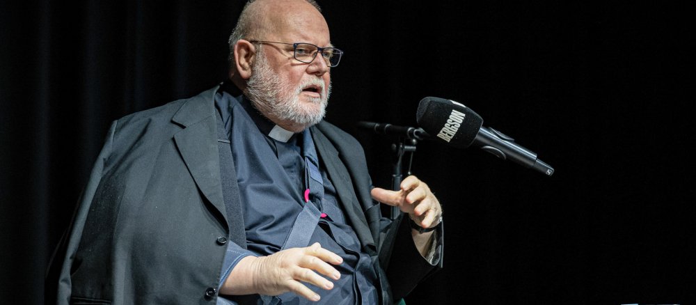 Kardinal Reinhard Marx mit Armschiene präsentiert sein neues Buch