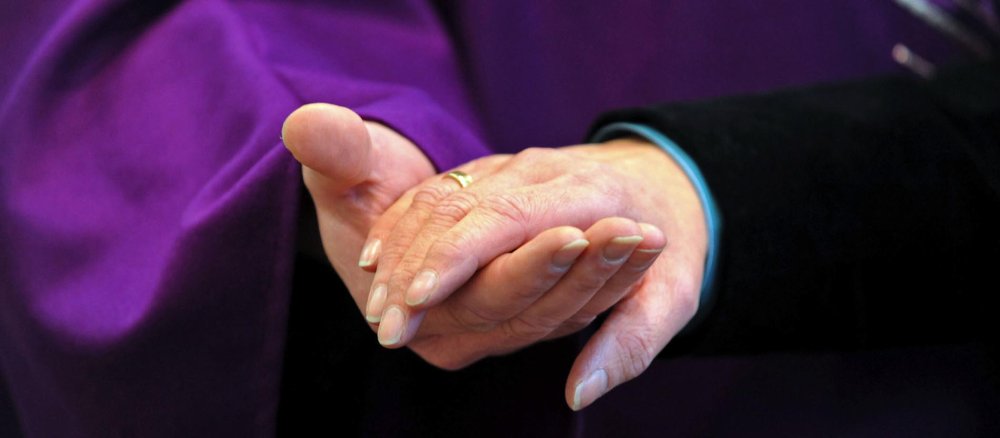 Priester hält Hand einer Frau